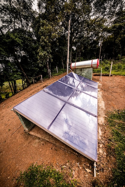 Foto kleine zonneverwarmer met zonnepanelen geïnstalleerd in landelijke gebieden van brazilië onzorgvuldige en onzekere apparatuur