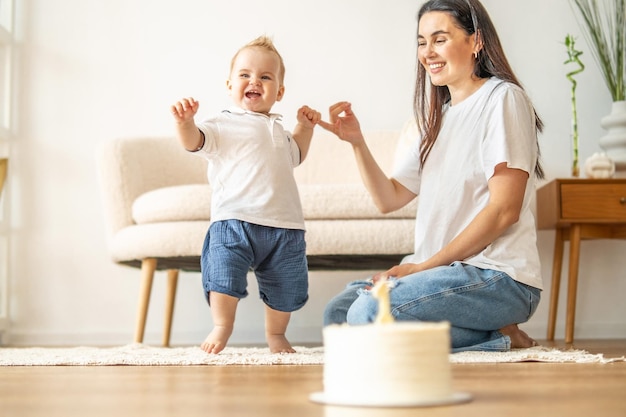 Foto kleinkind neemt de eerste stappen naar moeder in een heldere woonkamer