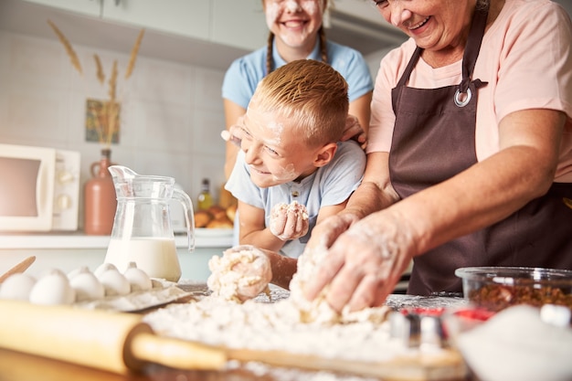 Kleinkinderen spelen met meel bij oma keuken