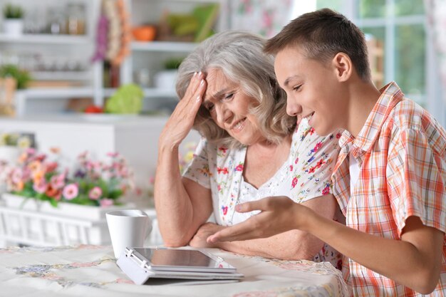 Kleinzoon leert grootmoeder tablet te gebruiken