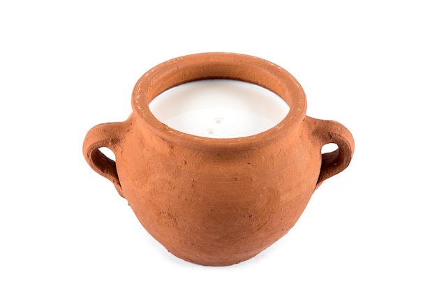 Kleipot met melk op witte achtergrond