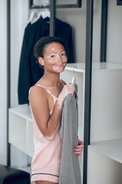 Kleren kiezen. een mooie jonge vrouw die kleren uit haar garderobe kiest