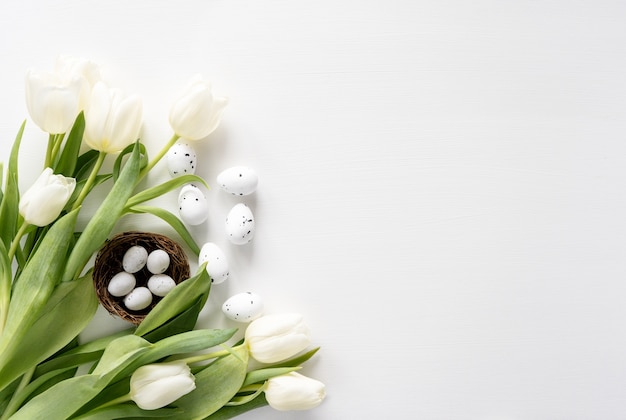 Kleur ei Pasen en wit boeket tulpen bloemen op witte achtergrond met kopie ruimte.