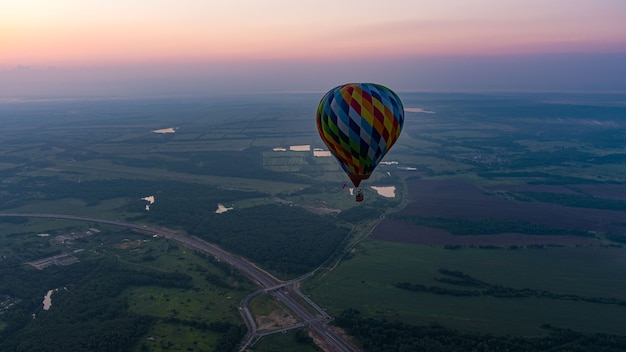 Kleur heteluchtballon in de luchtwolk en zonsopgangachtergrond in de ochtendtijd