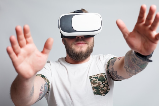 Kleurenfoto van een jonge man die door een virtual reality kijkt, een apparaat waarmee je virtual reality op een mobiele telefoon kunt ervaren. man raakt de hand aan. wazige foto's