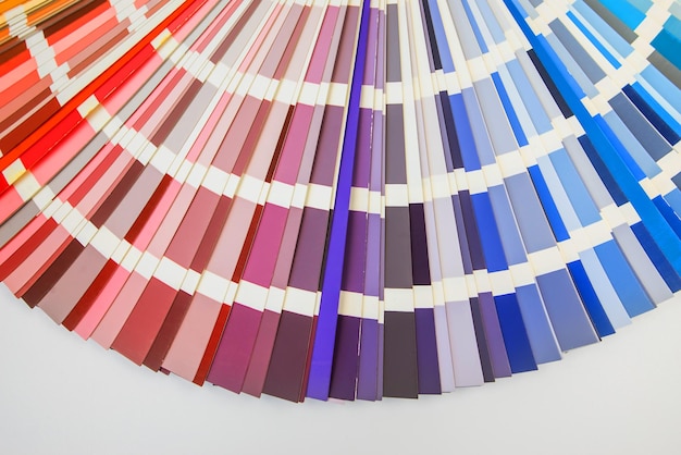 Kleurengids close-up Assortiment van kleuren voor ontwerp Kleurenpalet fan op witte betonnen muur achtergrond Grafisch ontwerper kiest kleuren uit de kleurenpaletgids Gekleurde stalen catalogus