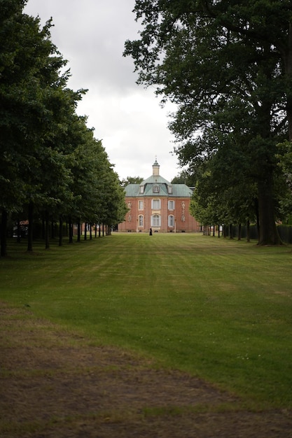 Kleurenlandschapsfoto met een bladerdak van eikenbomen die naar een huis leiden