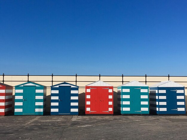 Foto kleurige hutten op het strand tegen een heldere blauwe lucht