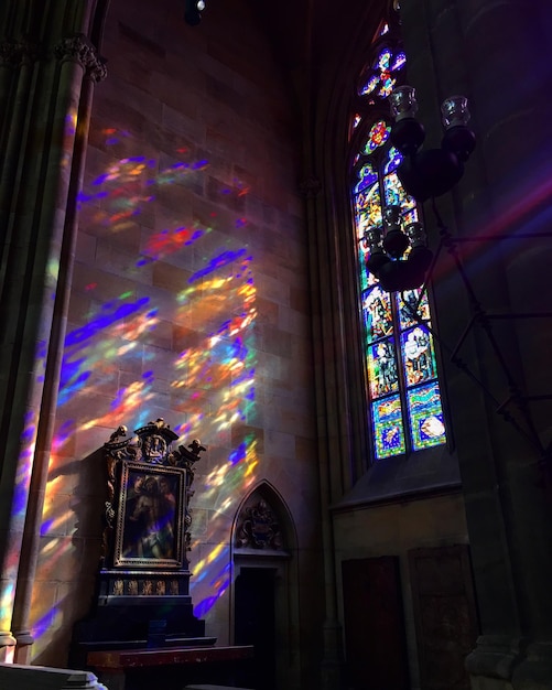 Foto kleurige lichten stromen op de muur door het gebrandschilderde glasvenster van de kerk