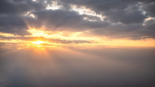 Kleurrijk aardlandschap en straal van zonlicht door wolken en blauwe hemel.