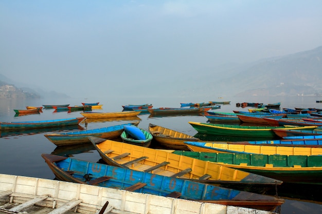 Foto kleurrijk bootsymbool van phewa-meerkust met mist in de ochtend, pokhara nepal.