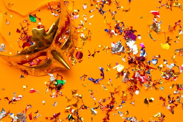 Kleurrijk carnavalsmasker op een oranje achtergrond met verschillende ornamenten