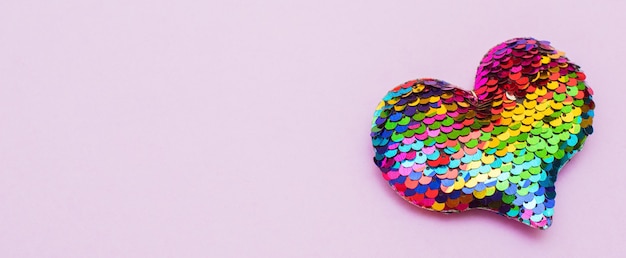 Kleurrijk hart gemaakt van pailletten op een roze achtergrond