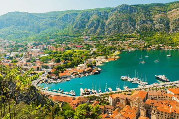 Kleurrijk landschap met boten en jachten in marina bay, zee, bergen, blauwe lucht. Bovenaanzicht van de baai van Kotor, Montenegro