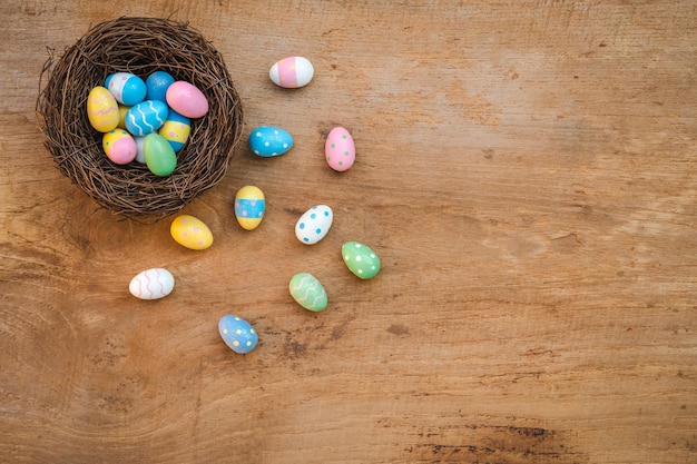 Kleurrijk paasei en nest op een rustieke oude houten achtergrond boven weergave met kopieerruimte