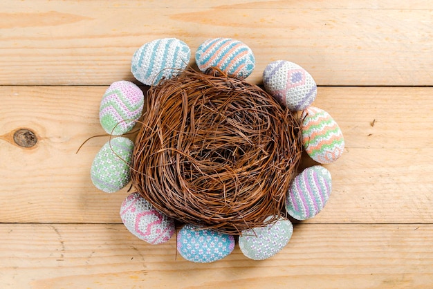 Kleurrijk paasei op het nest op een houten tafel Vrolijk Pasen