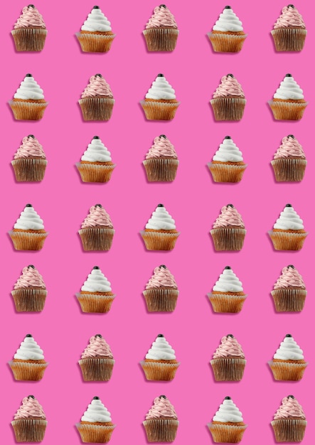 Kleurrijk patroon gemaakt van cupcakes op roze achtergrond. Minimaal begrip.