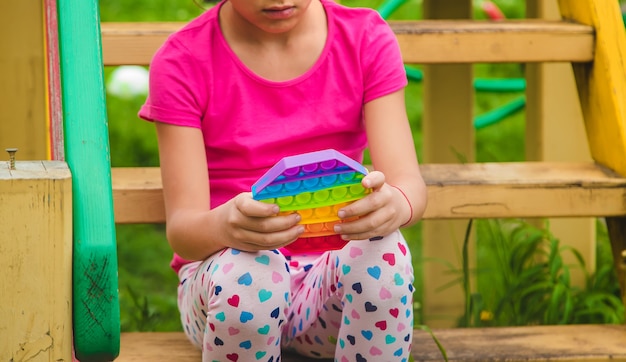 Kleurrijke antistress sensorische speelgoed fidget push pop het in kinderhanden. Selectieve aandacht. natuur.