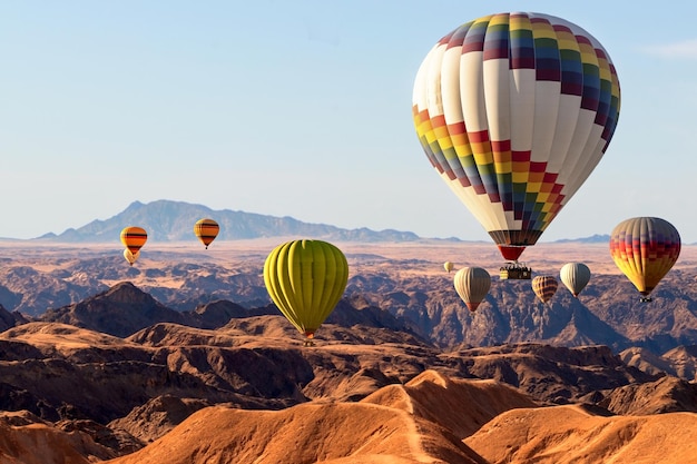 Kleurrijke ballonnen die over de berg van de maanvallei vliegen. afrika. namibië.