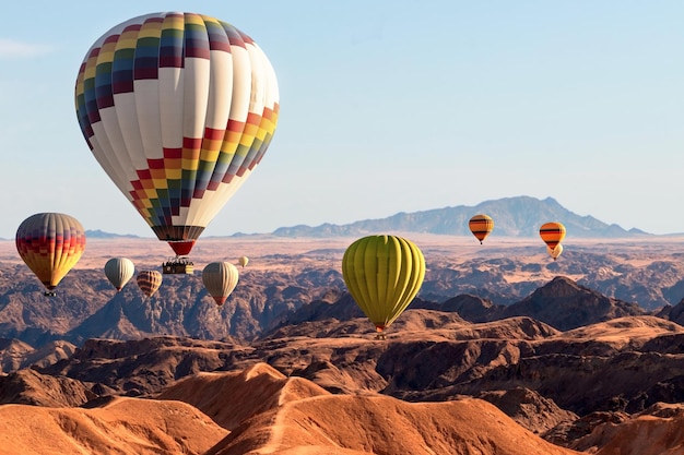 Kleurrijke ballonnen die over de berg van de maanvallei vliegen. Afrika. Namibië.