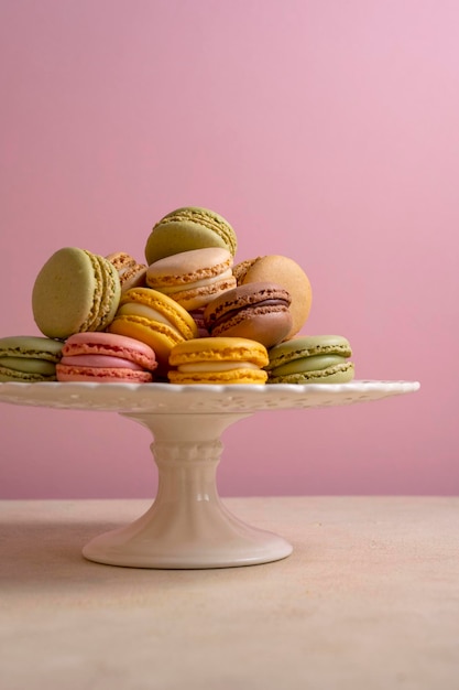 Kleurrijke bitterkoekjes Franse heerlijke koekjes op cake stand roze achtergrond Sweet