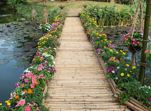 Kleurrijke bloem met ingang van een bamboebrug