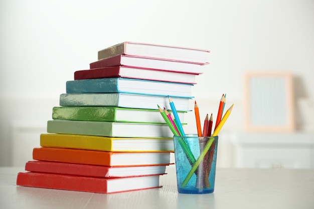 Kleurrijke boeken en potlood op tafel in de kamer