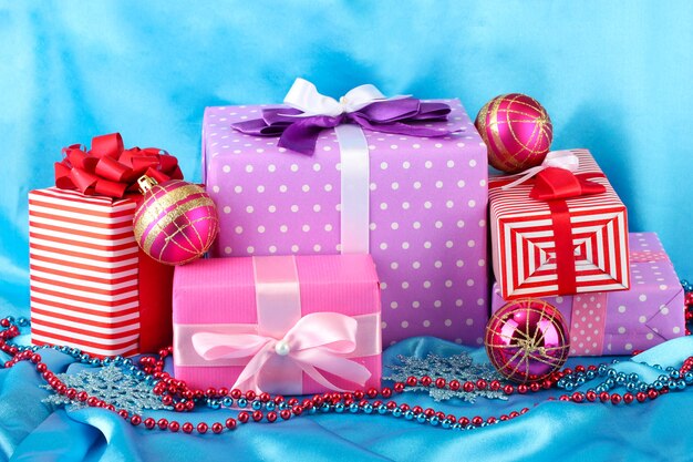Kleurrijke cadeaus met roze kerstballen, sneeuwvlokken en kralen