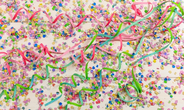 Foto kleurrijke carnaval confetti en serpentines op houten achtergrond boven nieuw