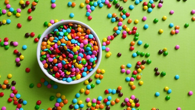 Kleurrijke confetti verspreid over groene tafel, bovenaanzicht.