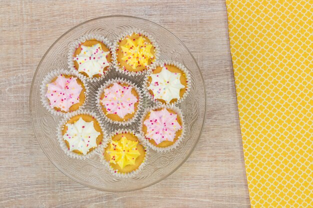 Kleurrijke cupcakes op een witte houten achtergrond. Bovenaanzicht met ruimte voor uw tekst.