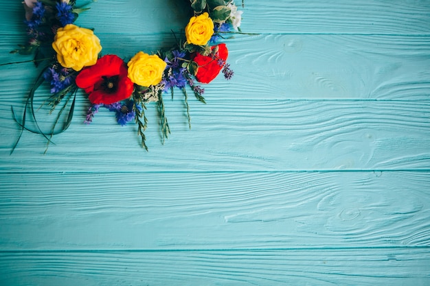 Kleurrijke decoratieve kunstbloemen op blauwe houten achtergrond