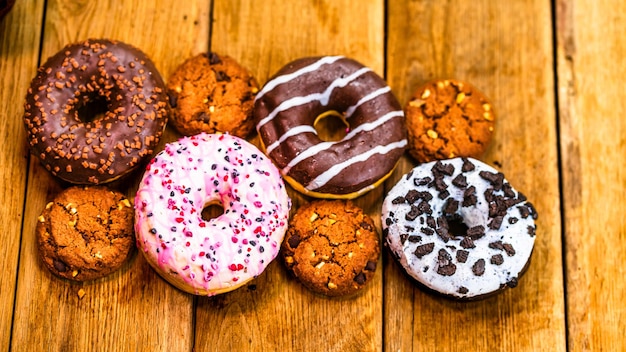 Kleurrijke donuts op een houten tafel Zoete glazuur suiker voedsel met geglazuurde sprinkles donut met chocolade glazuur Bovenbeeld met kopieerruimte