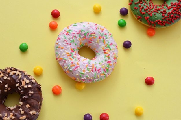 Kleurrijke donuts op gele achtergrond plat lag