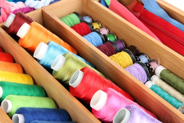 Kleurrijke draden voor handwerk in houten kist close-up