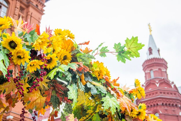 Kleurrijke esdoorn bladeren zonnebloemen en meidoorn bessen Rode bakstenen toren op background