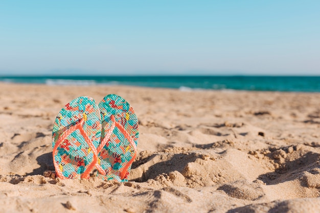 Foto kleurrijke flip-flops in zand