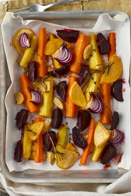 Kleurrijke geroosterde groenten op dienblad met perkament. Mix van wortelen, bieten, rapen, rutabaga