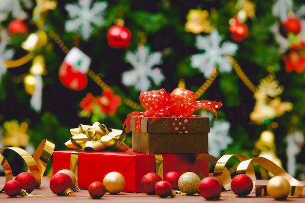 Kleurrijke geschenkdozen met een vlinderdas in felle kleuren vooraan geplaatst volledig decoratieve mooie kerstavond dennenboom.