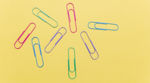 Kleurrijke grote paperclips op gele kleur achtergrond