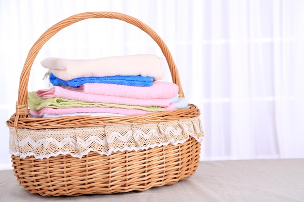 Kleurrijke handdoeken in mand op lichte achtergrond