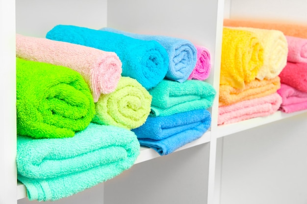Kleurrijke handdoeken op planken in de badkamer