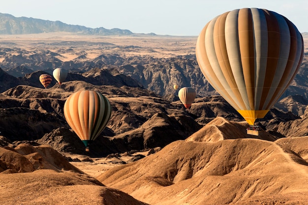 Kleurrijke heteluchtballonnen die over de berg Afrika van de maanvallei vliegen
