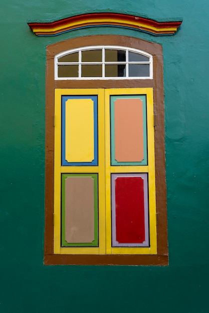 Foto kleurrijke houten abstracte venster, close-up. koloniale stijl architectuur gebouw in little india, singapore city. achtergrond en textuur van heldere architectuur