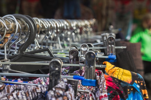 Kleurrijke jurken aan in een straatkraam, stadsmarkt, close-up