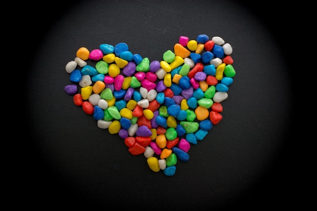 Kleurrijke kleine kiezelstenen vormen een hartvorm