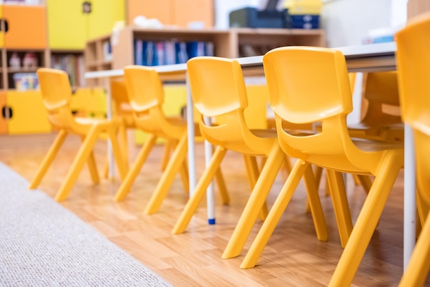 Kleurrijke kleuterklas zonder kinderschoolonderwijs bureaustoel speelgoed en decoratie op achtergrondmuur Kindertijd