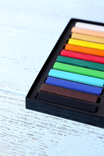 Foto kleurrijke krijt pastels in een doos op houten achtergrond