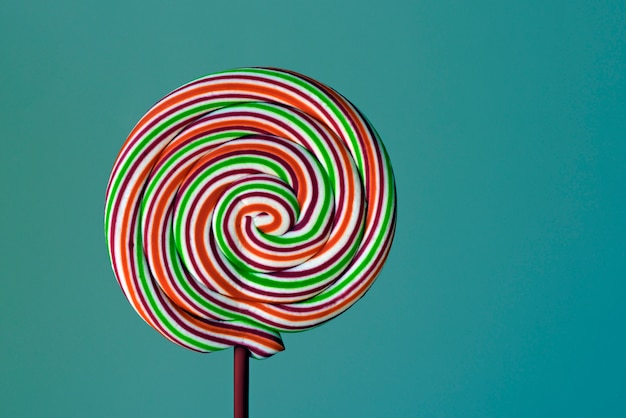 Kleurrijke lollipop in spiraalvorm op groene achtergrond