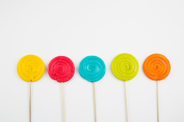 Kleurrijke lolly's en verschillende gekleurde ronde snoepjes. Bovenaanzicht.